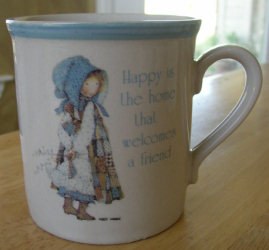 Holly Hobbie Blue Girl Coffee Mug Happy is the home that welcomes a friend